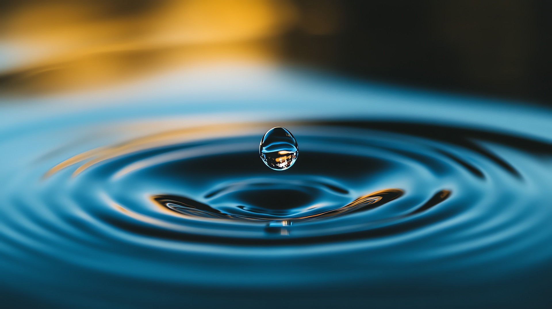Nahaufnahme eines Wassertropfen der ins Wasser und Wellen generiert